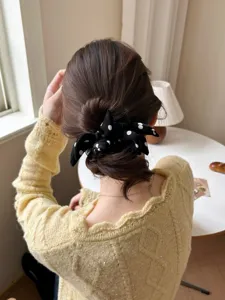 Close-up of a black and white polka dot bow scrunchie on a bun hairstyle