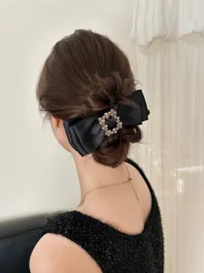 Back view of elegant black bow hair clip with rhinestone square buckle on hairstyle