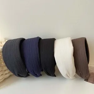 Close-up of five ribbed texture fabric headbands in different neutral colors for hair styling