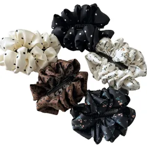 Set of elegant polka dot and floral ruffled fabric banana hair clips for women.