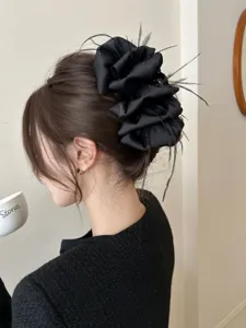 Large black ruffled fabric hair claw clip accented with feathers and glitter effect