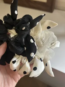 Macro detail of elegant polka dot bow scrunchies in contrasting black and white