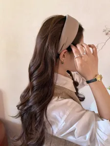 Primer plano de una diadema ancha color topo de estilo coreano para volumen de cabello