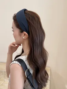 Elegante diadema ancha azul marino para peinado de moño alto en cabello largo ondulado
