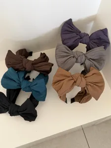 Vue détaillée de plusieurs serre-têtes à gros nœud de couleur unie avec texture