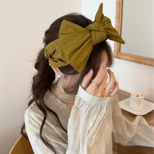 Serre-tête femme à gros nœud en tissu vert moutarde, design élégant pour volume de tête