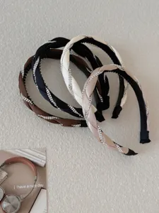Close-up detail of rhinestone embellishments on braided headbands in various colors