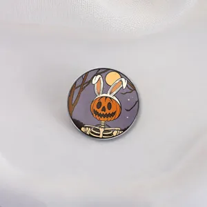 Halloween emaille speldje met pompoen skelet en konijnenoren op een paarse achtergrond.
