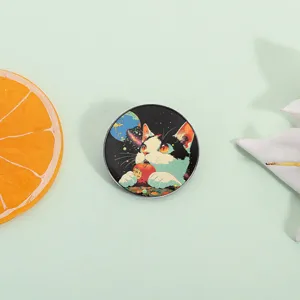 Creative artistic enamel pin featuring a calico cat in space eating a red apple