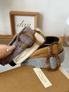 Close-up view of cozy knitted wide headbands featuring stylish amber resin buckle accents