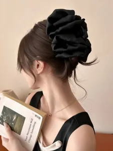 Detailed view of an elegant oversized black rhinestone bubble hair claw clip on model