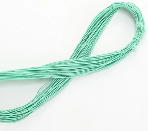 Primer plano detallado de cordón elástico verde claro para cuentas, flexible y muy resistente.