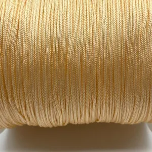 Detailed close-up of fine golden nylon jade cord spool, perfect for DIY handmade jewelry crafting.