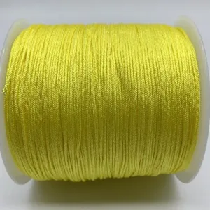 Close-up detail shot of bright yellow nylon jade thread wrapped neatly on spool for crafting.