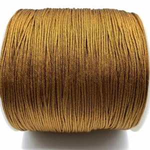 Close-up detail of golden braided cord on spool, perfect for DIY handmade crafts and jewelry.