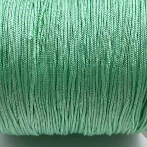 Close-up detail of light green handmade jade cord, smooth texture for DIY jewelry making.