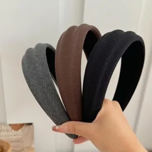 Close-up of three textured flocked headbands in grey, brown, and black for daily wear