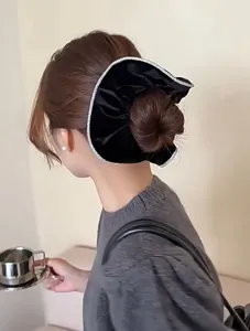 Λεπτομέρεια μαύρου βελούδινου scrunchie με στρας σε κότσο μαλλιών