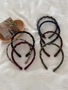 Close-up of retro wool-wrapped headbands in various colors featuring non-slip teeth