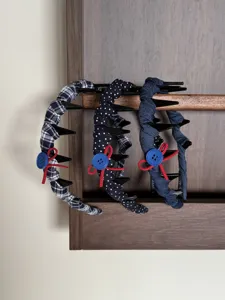Close-up of navy blue series fabric headbands with anti-slip combs and button bow detail