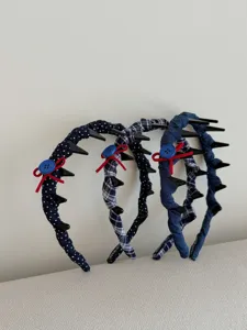 Detail shot of three navy blue fabric headbands featuring polka dots and plaid patterns.