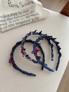 Detail of navy blue polka dot and plaid fabric headbands with non-slip teeth and bows.