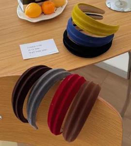 Collezione di cerchietti in velluto a righe multicolore su un elegante tavolo in legno