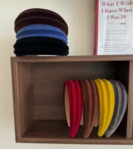 Assortimento di cerchietti larghi e imbottiti in velluto per donne su uno scaffale in legno