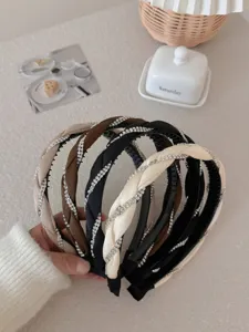 Detail of vintage rhinestone braided headbands in cream, brown, and black colors.