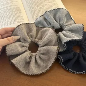 Macrodetail van drie getextureerde wollen scrunchies met elegante zigzagranden.