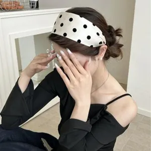Bandeau large en mousseline à pois porté par un mannequin pour un look d'accessoire mode