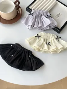Close-up of elegant pleated ruffled skirt hair clips with small bow ties and pearls