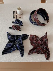 A diverse collection of navy and brown plaid hair accessories, headbands, and clips