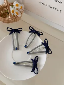 Κομψό σετ από 4 κλιπ μαλλιών με μπλε σκούρο φιόγκο και λεπτομέρειες από μπλε πολύτιμο λίθο.