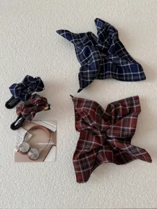 Detailed close-up of navy blue and burgundy plaid bow hair clips and hair scrunchies