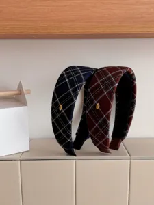 Close-up of retro plaid wide headbands in dark blue and brown colors.