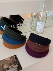 Close-up shot of various ribbed padded headbands in forest green, blue, and brown colors