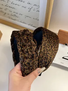 Close-up of leopard print velvet headband with braided and smooth texture details.