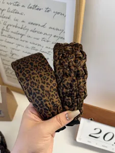 Close-up detail of leopard print velvet headbands in smooth and braided textures.
