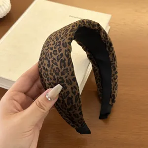 Detailed view of a wide velvet headband with a leopard print pattern and sponge padding