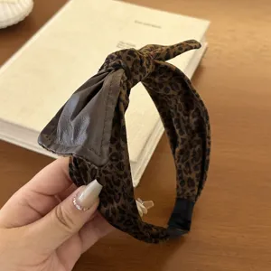 Detailed view of luxury velvet leopard print wide headband with stylish leather bow