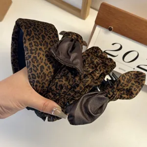 Stylish leopard velvet wide headband with dark brown leather bow detail for women.