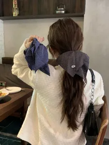 Close-up view of oversized polka dot hair scarf scrunchies styled on a ponytail