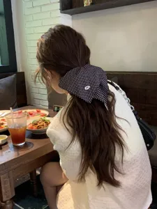 Elegant polka dot hair scrunchie for women, stylish ponytail accessory in cafe setting