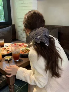 Detailed view of a Korean style black and white checkered hair scarf tied on a ponytail