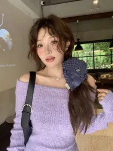 Close-up of a blue polka dot large hair scrunchie styled on model with purple sweater