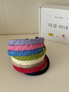 Farbfreudiger Stapel plissierter Stoffstirnbänder im minimalistischen Korea-Stil