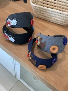 Detailed view of wide knitted headbands with cute animal embroidery and buttons