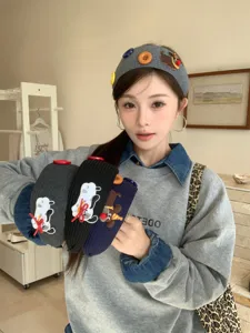 Model wearing a grey knitted headband with cute dog embroidery and button accents.