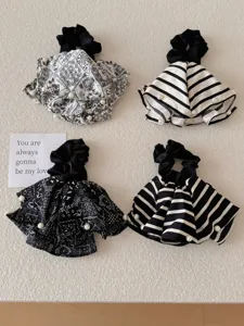 Close-up of black and white paisley and striped hair scrunchies with pearl details
